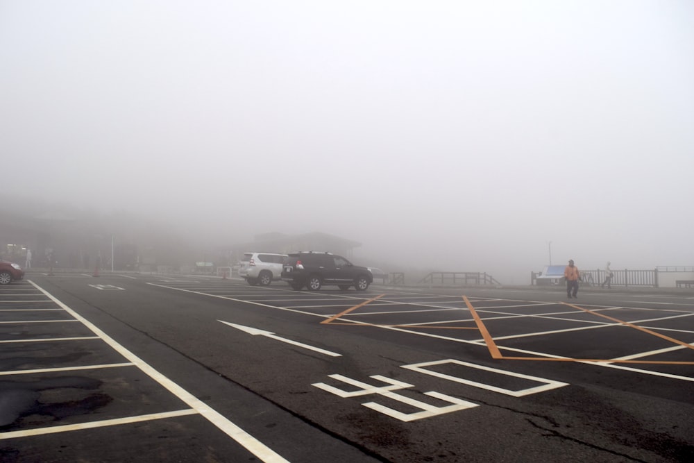 a foggy parking lot with cars parked in it