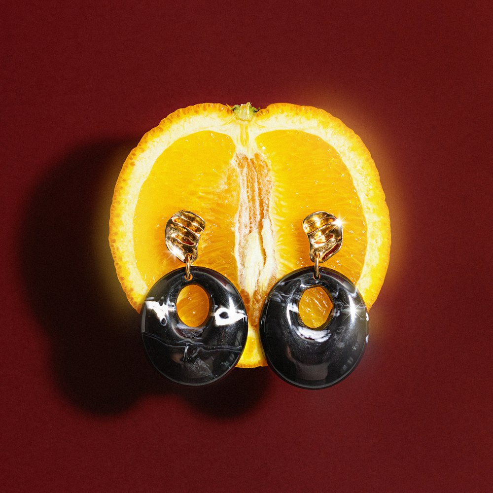 an orange cut in half with a pair of earrings