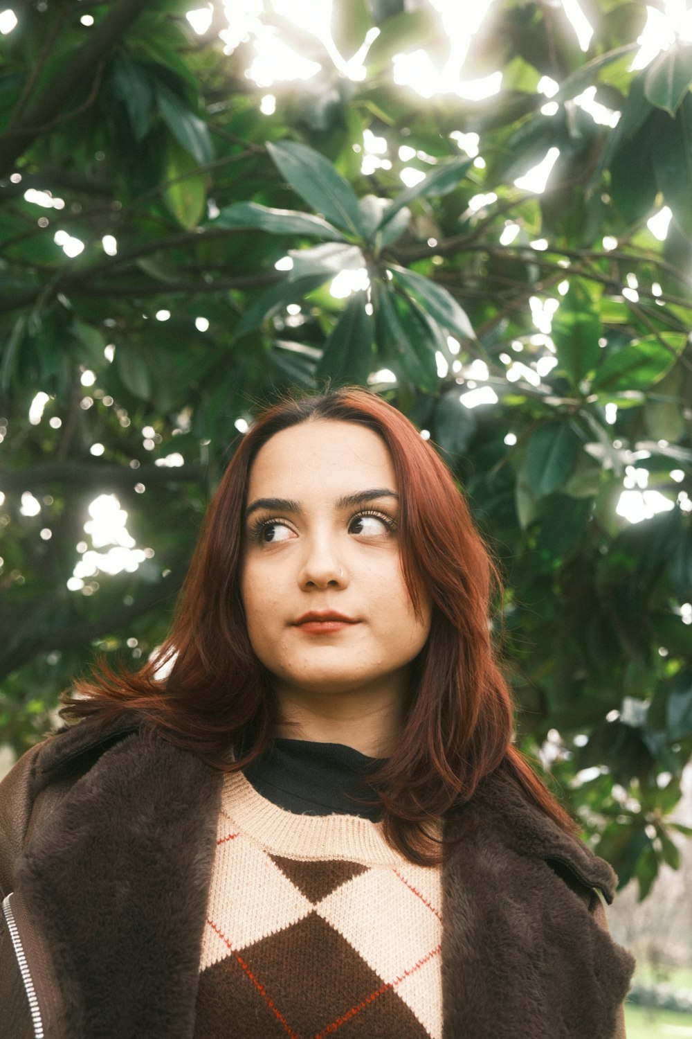 a woman with red hair wearing a brown coat