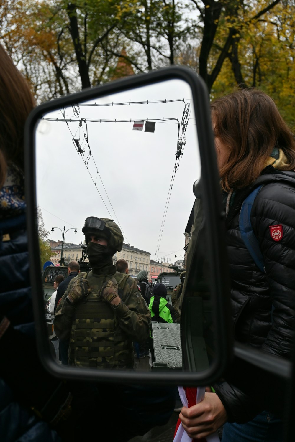 a man in camouflage is reflected in a rear view mirror