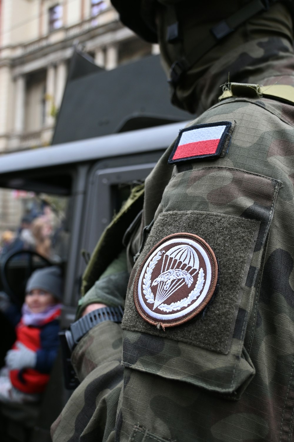 a man in a camouflage jacket is standing in front of a truck