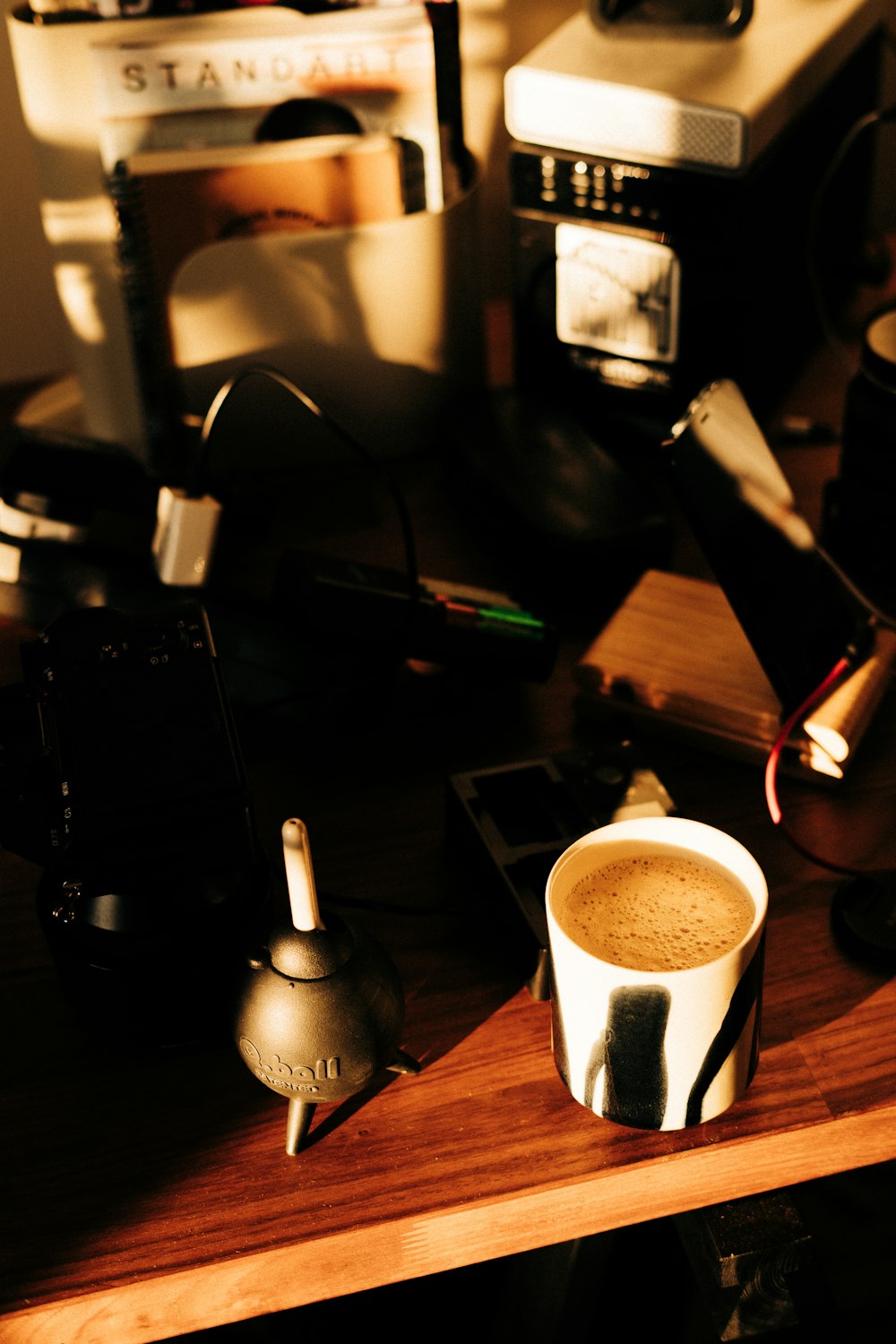 a cup of coffee sitting on top of a wooden table