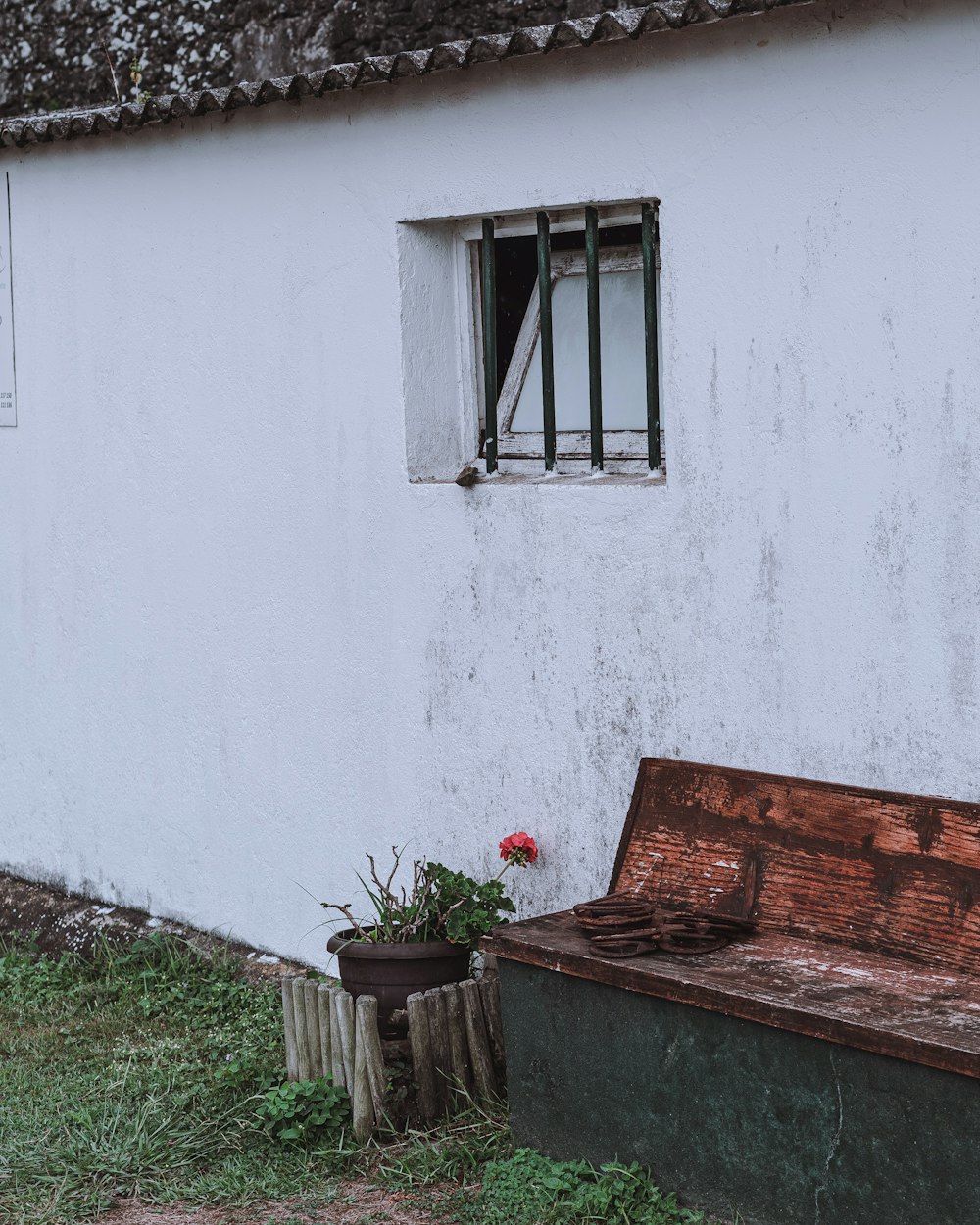 a wooden bench sitting in front of a white building