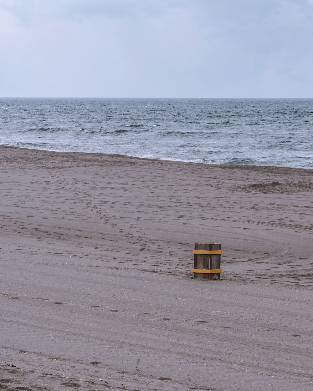 a bucket sitting on top of a sandy beach