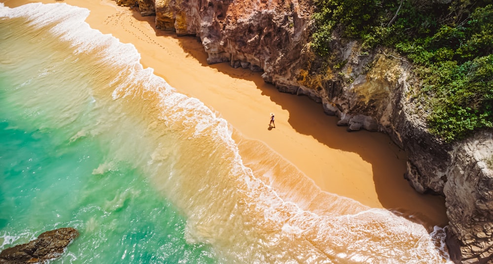 a person standing on a beach next to the ocean