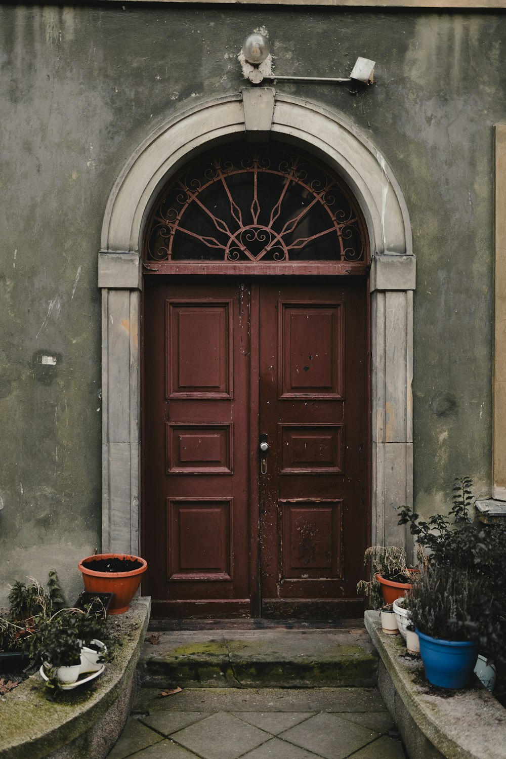a red door with two planters in front of it