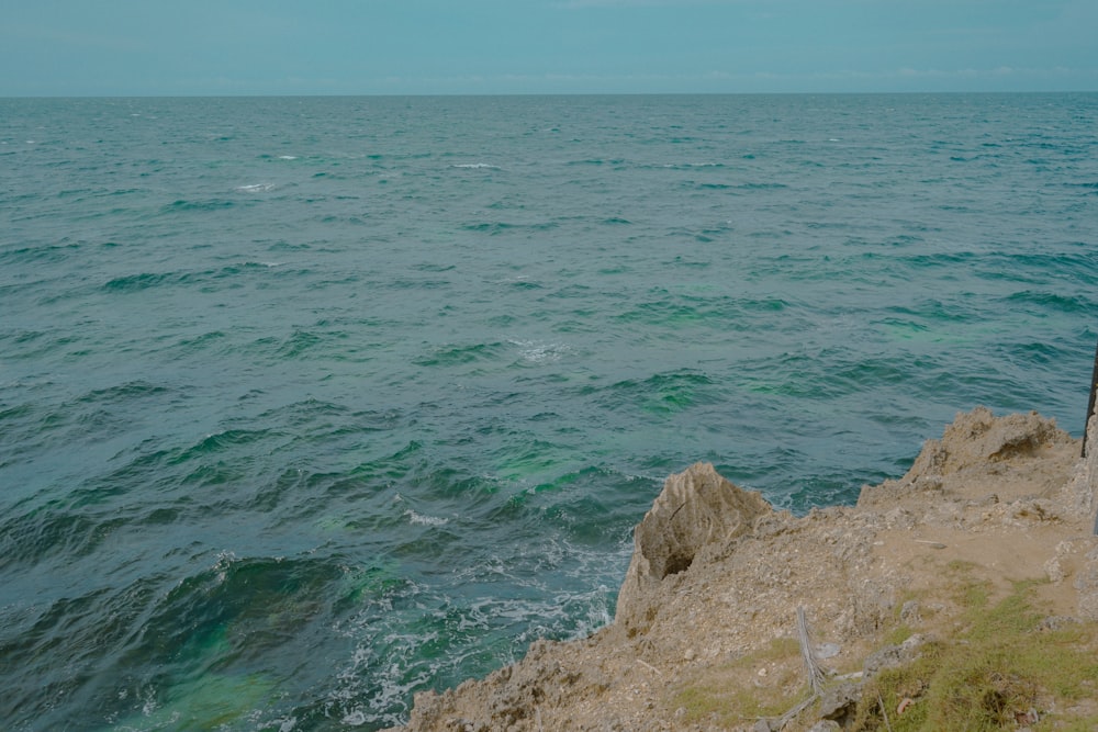 a person standing on a cliff overlooking the ocean