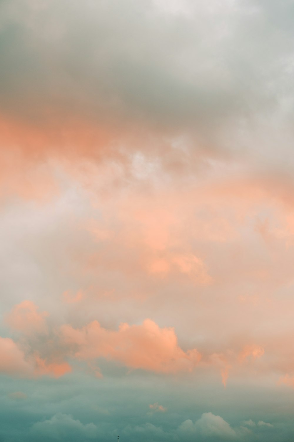 a plane flying in the sky with a pink and blue sky in the background