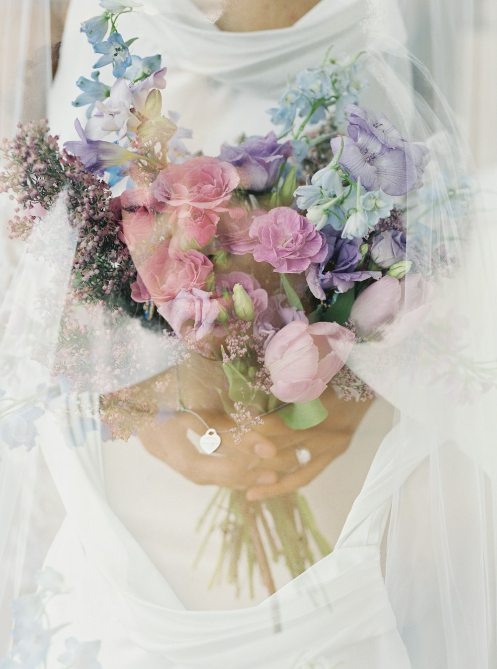 a woman wearing a veil holding a bouquet of flowers