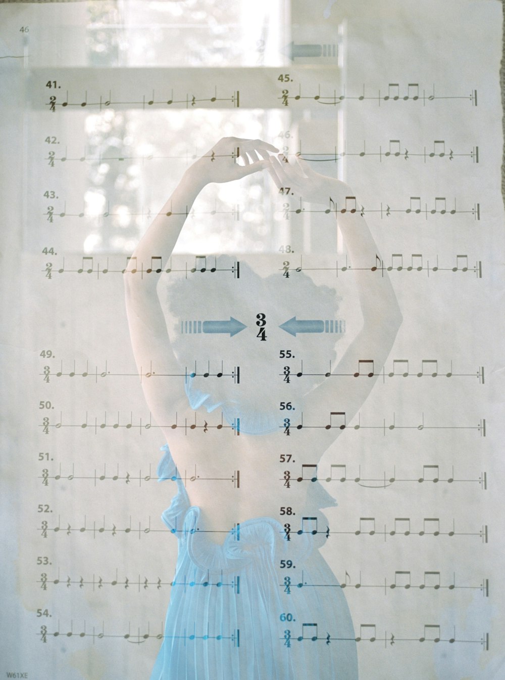 a woman in a blue dress standing in front of a window