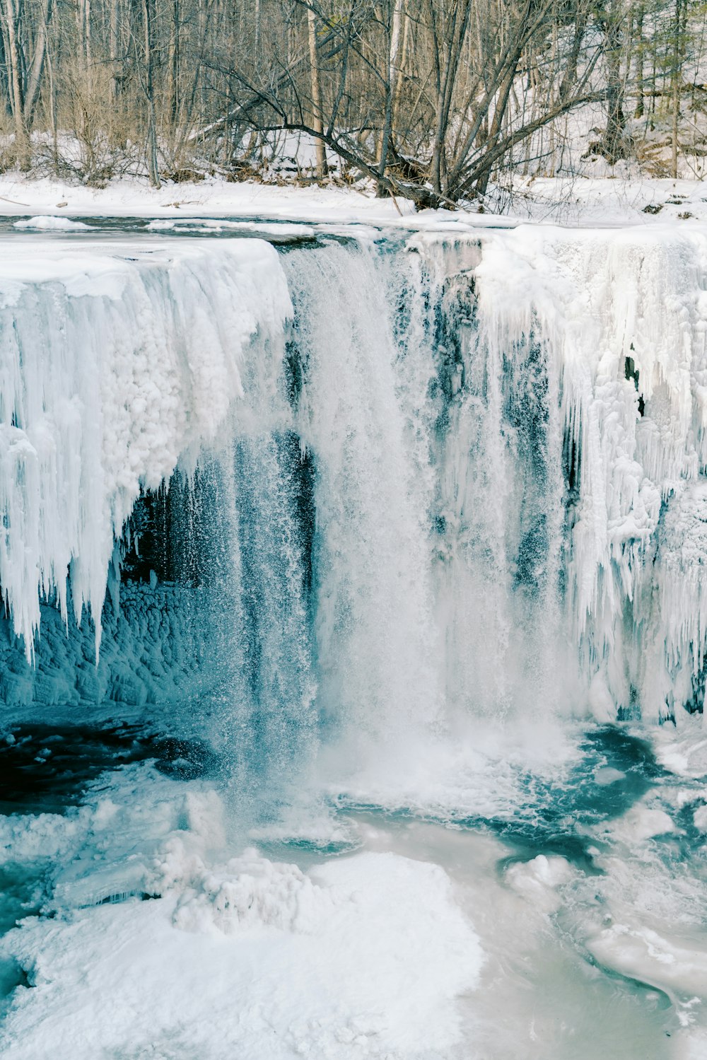 a large waterfall with ice hanging off of it's sides