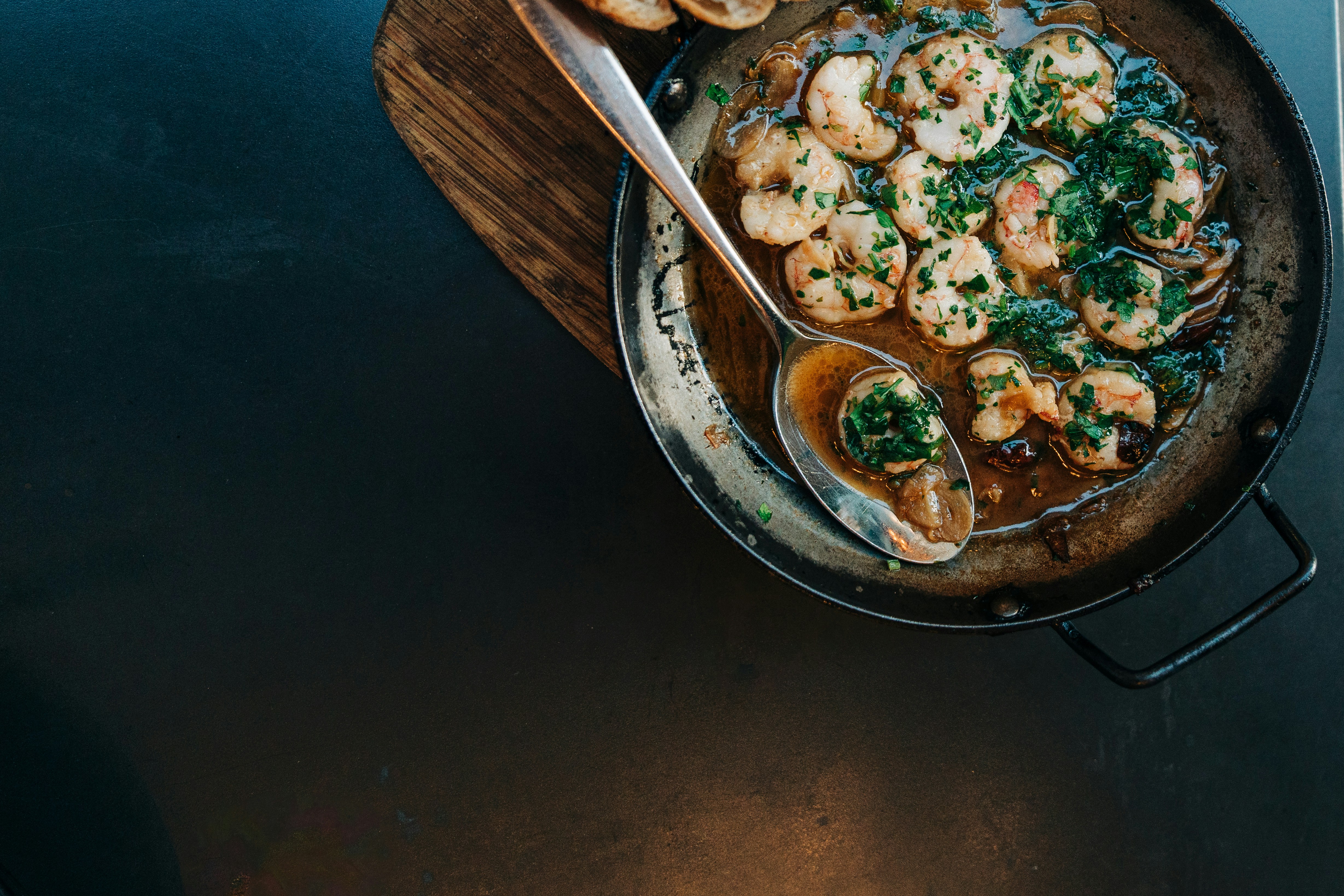 A skillet filled with shrimp and spinach