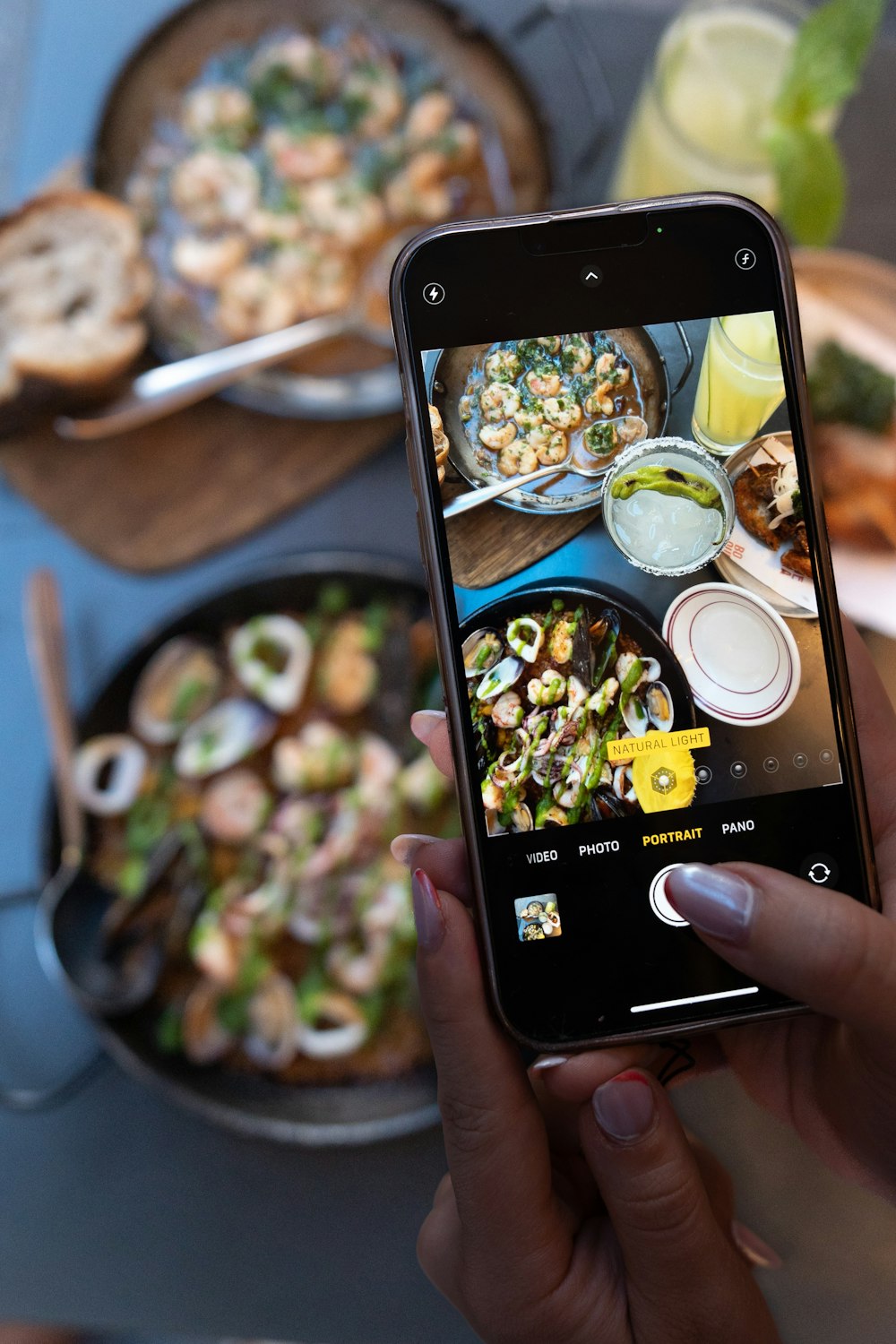 eine Frau, die mit ihrem Handy ein Foto von Essen macht