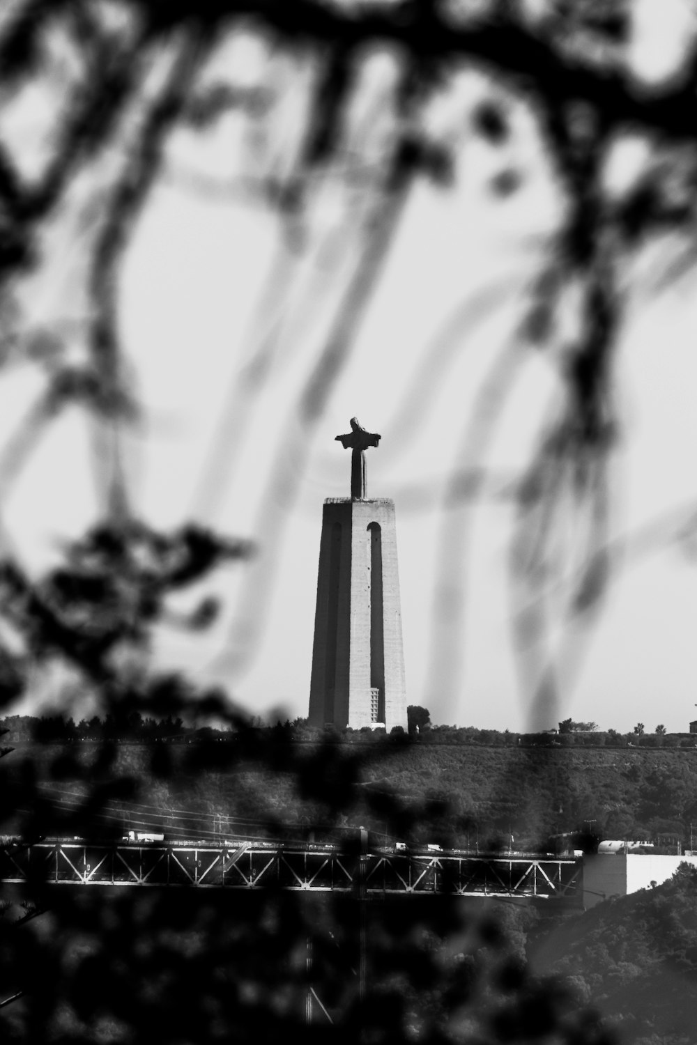 a black and white photo of a cross on top of a hill