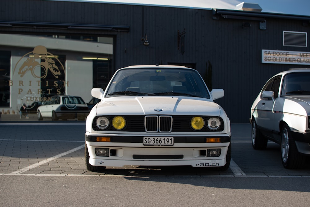 a white car parked next to a white car in a parking lot