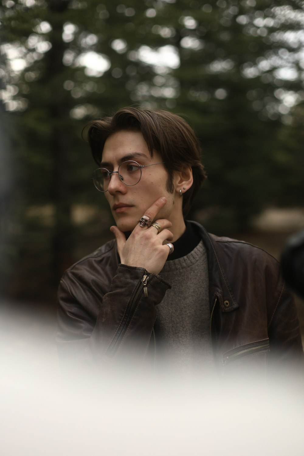 a man in a brown leather jacket and glasses