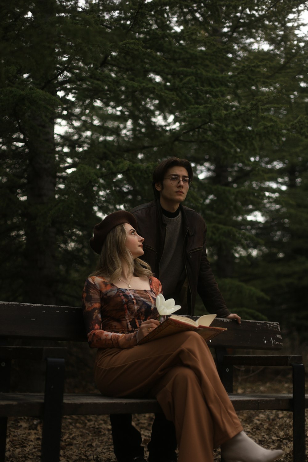 a woman sitting on a bench next to a man