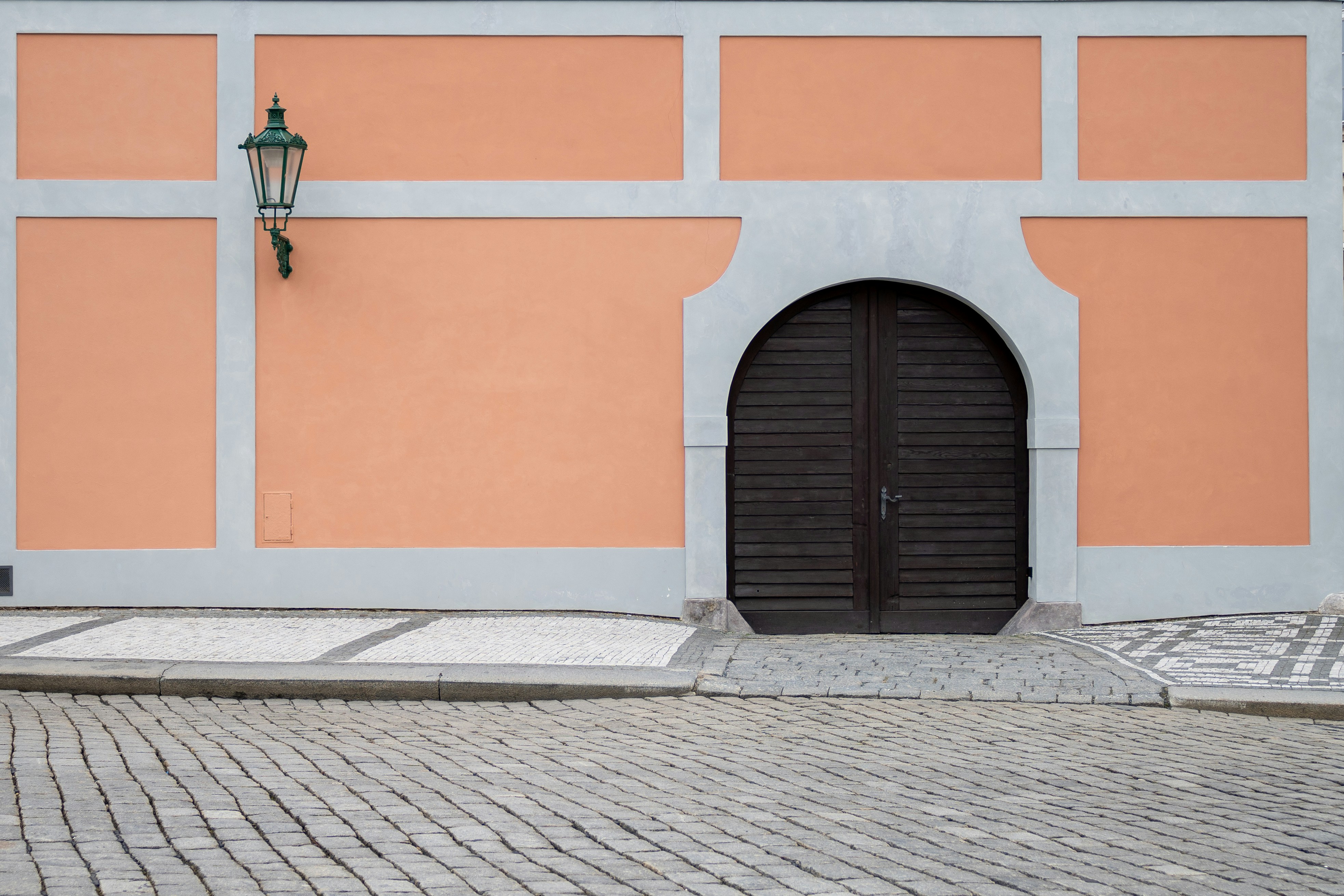 a building with a door and a lamp on the side of it
