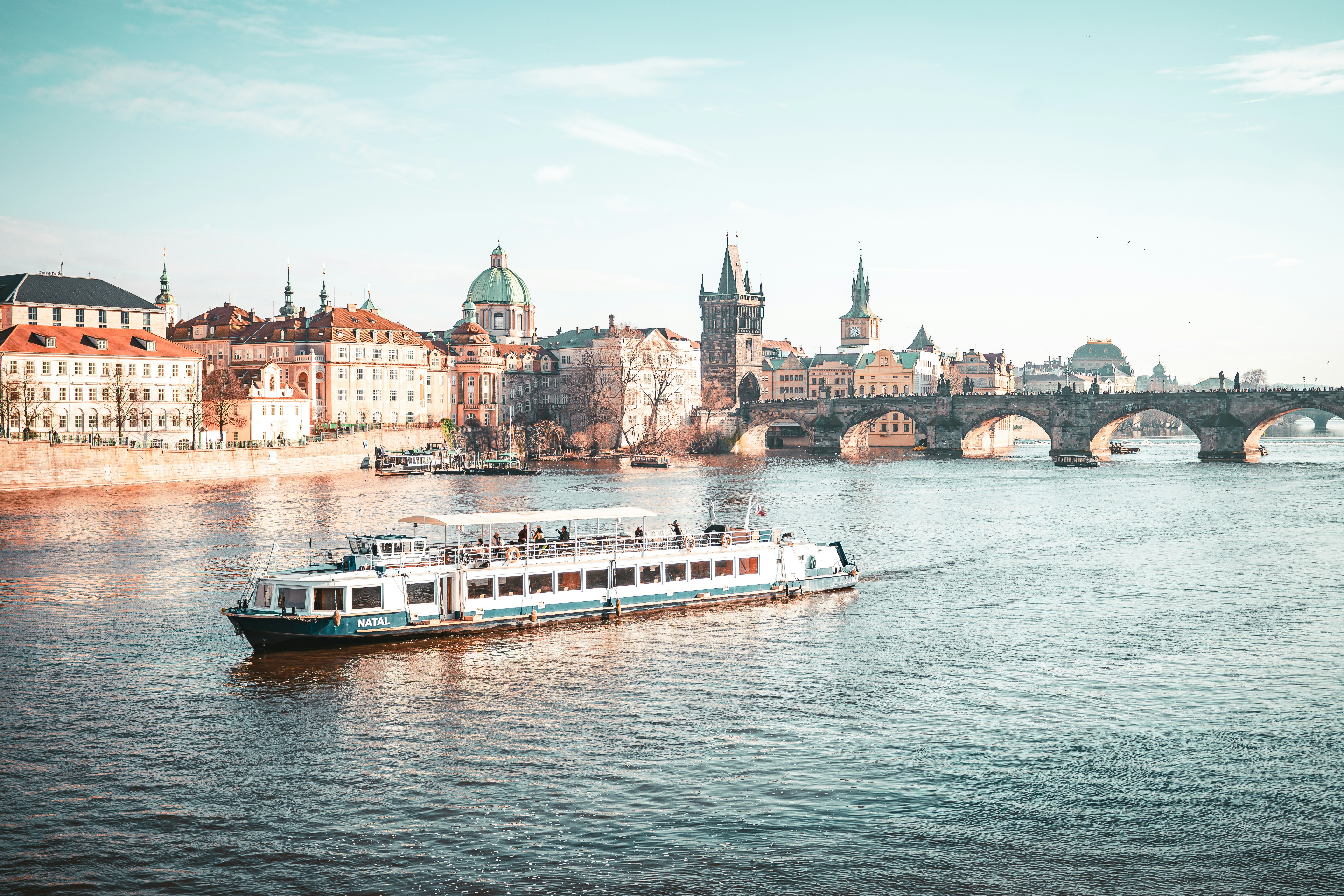 a large boat traveling down a river next to a bridge