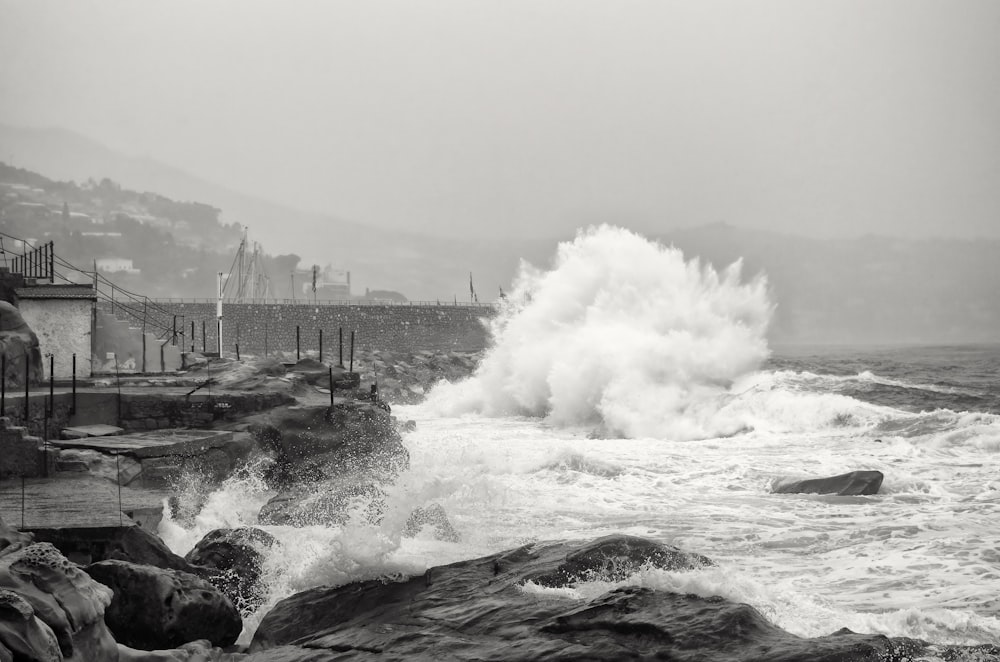 a black and white photo of a crashing wave