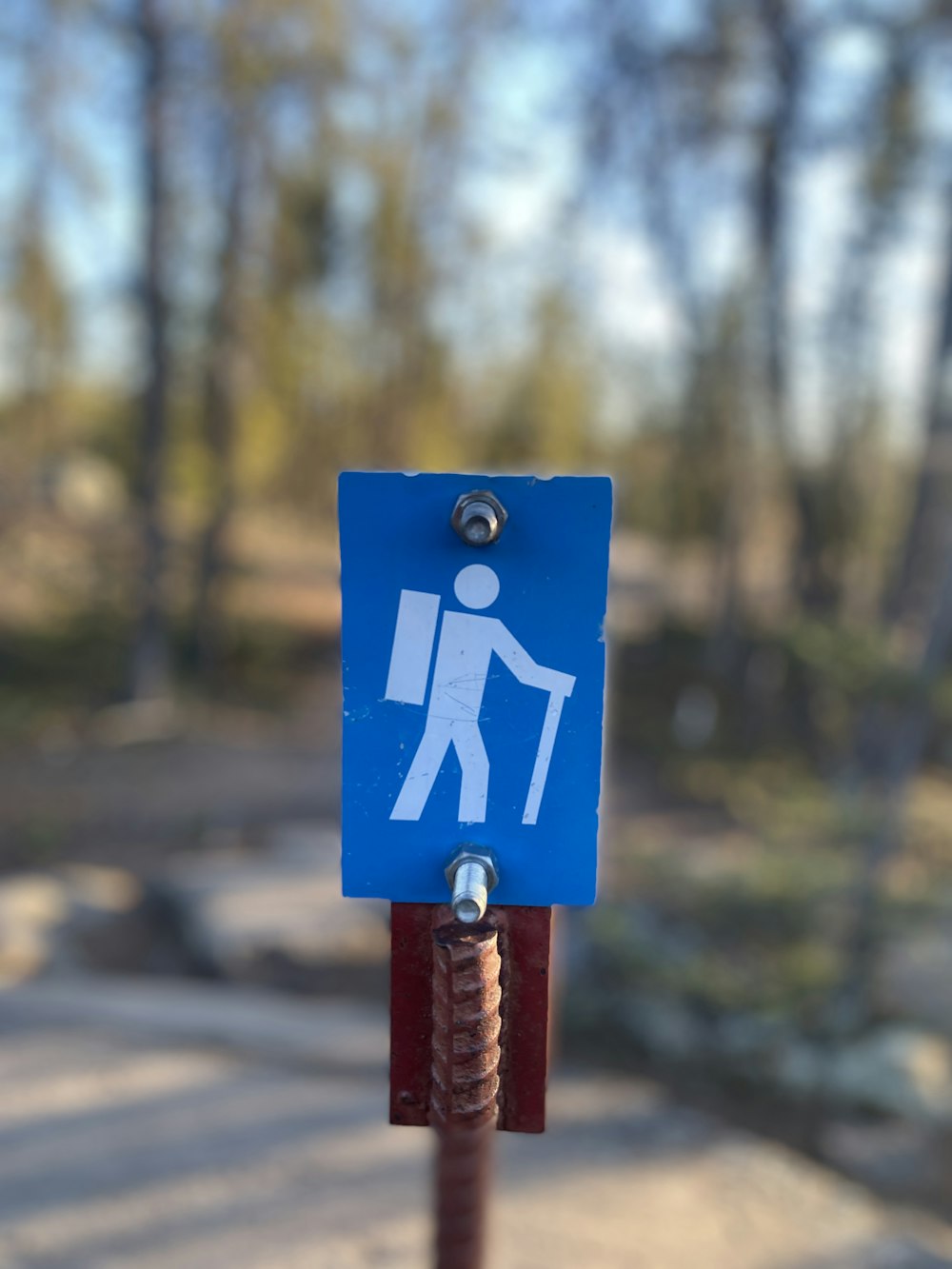 un letrero azul con un hombre sosteniendo un palo