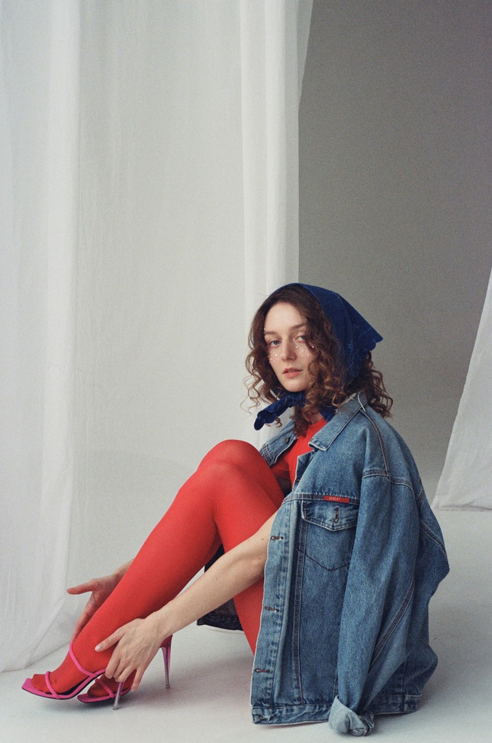 a woman sitting on the floor wearing red tights