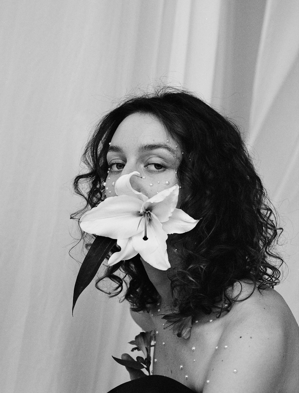 una foto in bianco e nero di una donna con un fiore in bocca