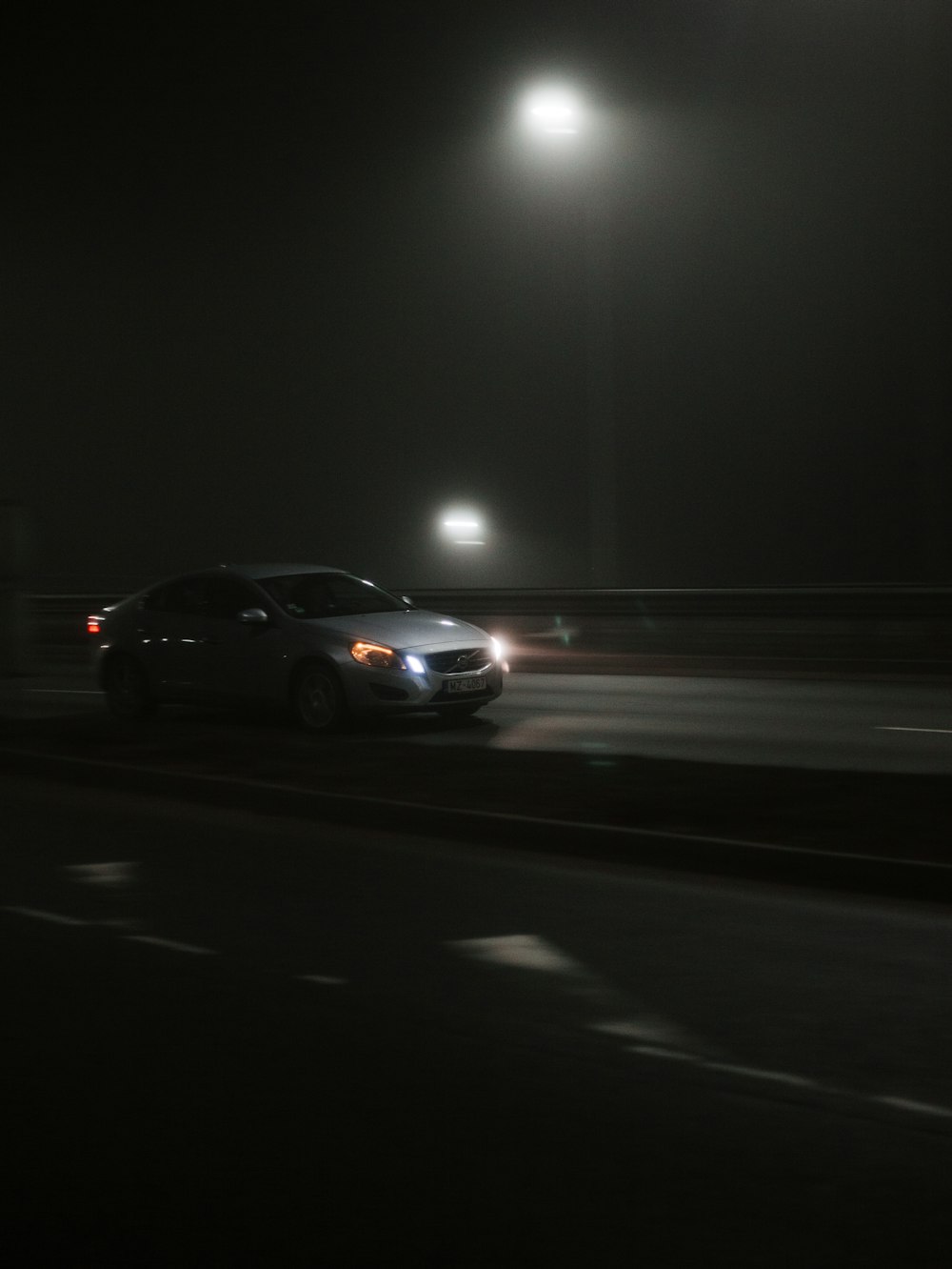 a car driving down a street at night