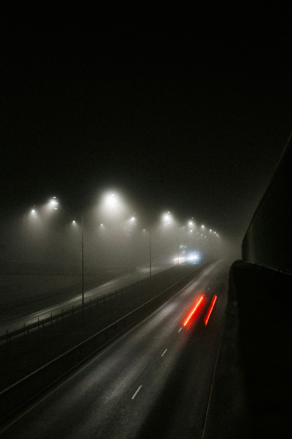 a foggy night on a highway with lights