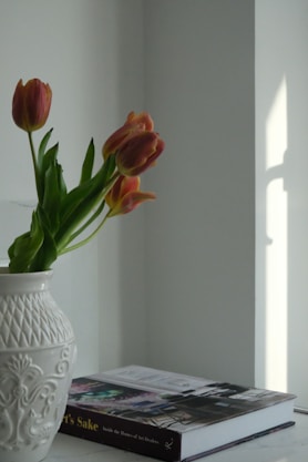 a white vase filled with flowers on top of a table