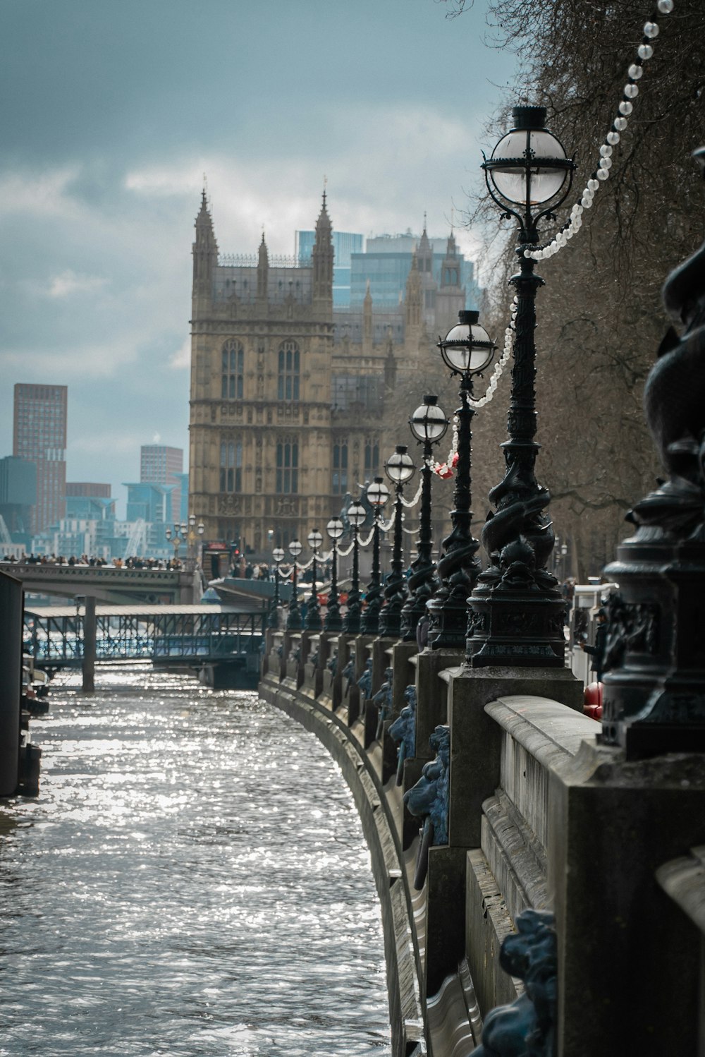 a row of street lights along the side of a river