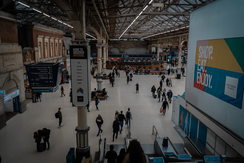 a group of people walking around a train station