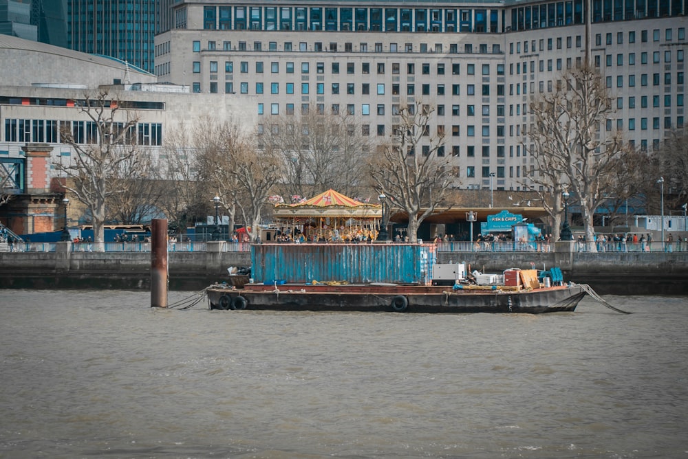 a boat floating on top of a river next to tall buildings