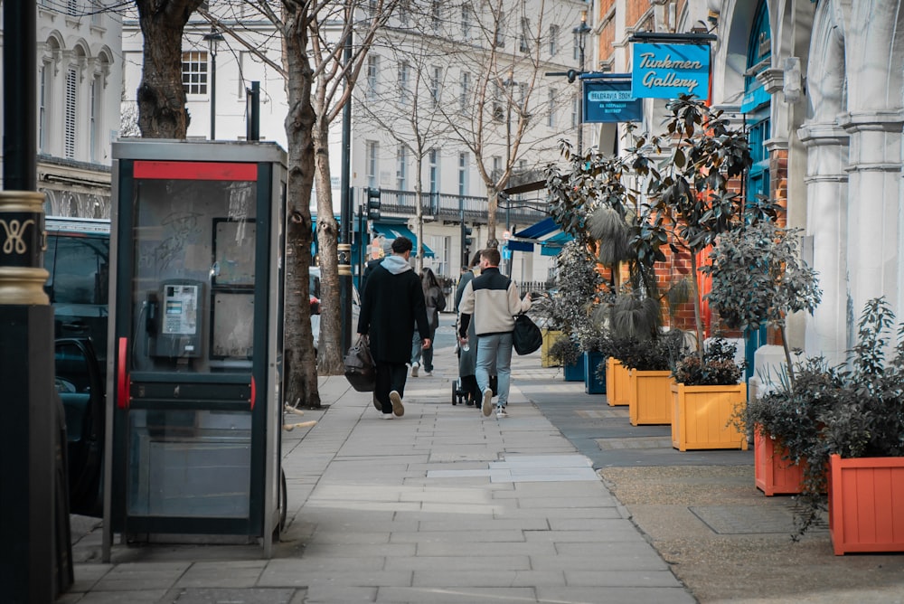 a group of people walking down a sidewalk