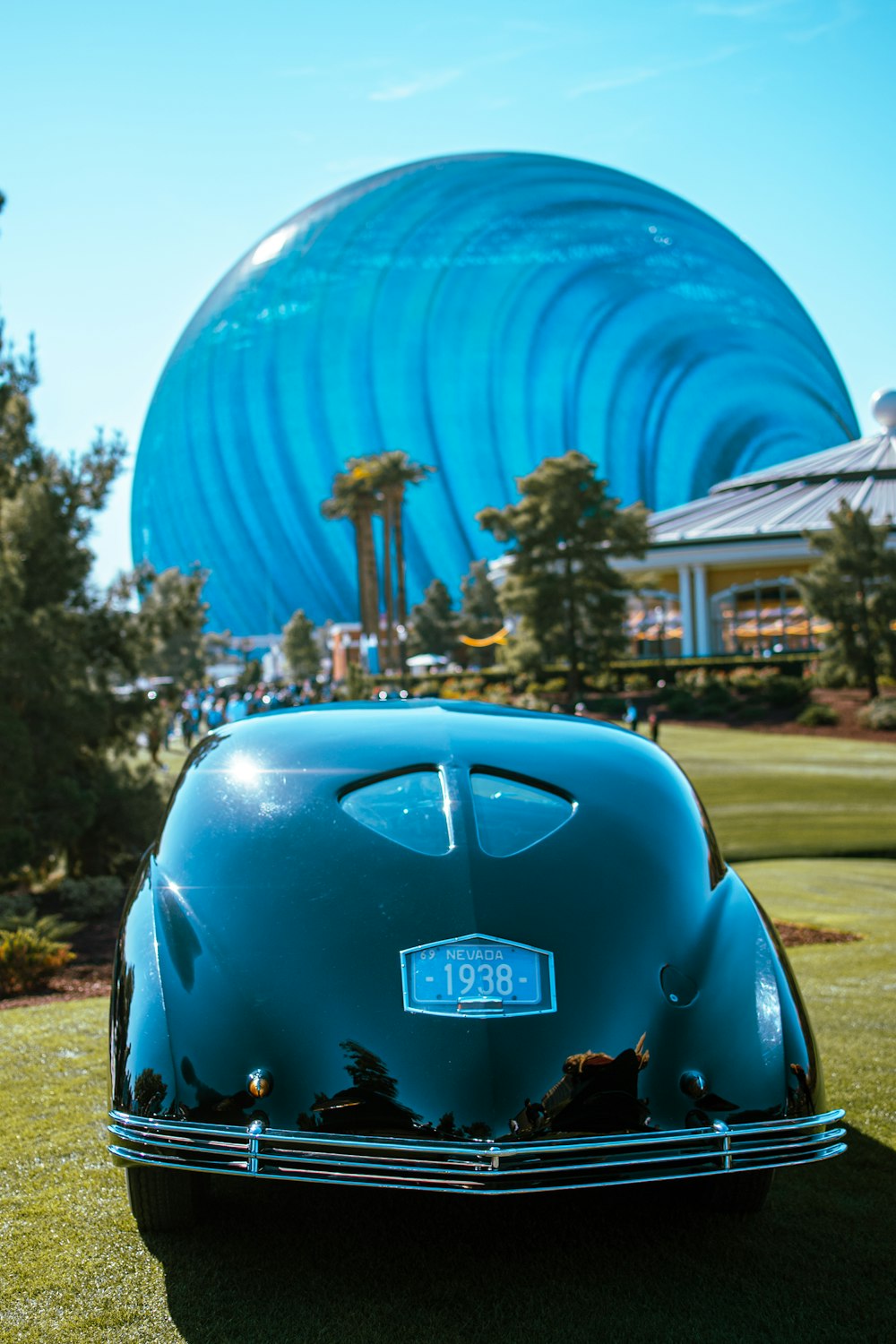 a blue car parked on top of a lush green field