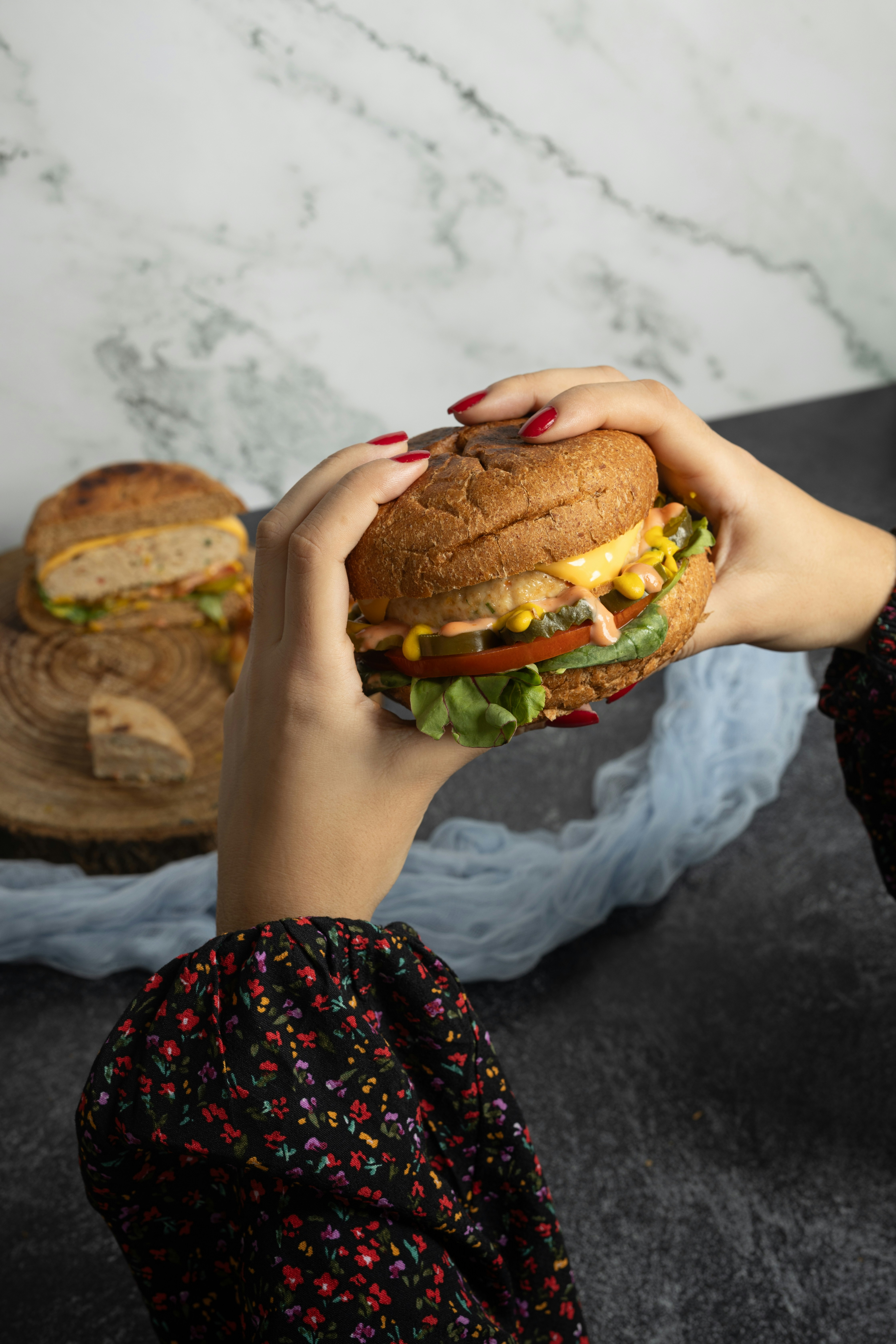 Klassieke burger met kaas en sla op een sesambroodje, warm zijlicht, donkere achtergrond