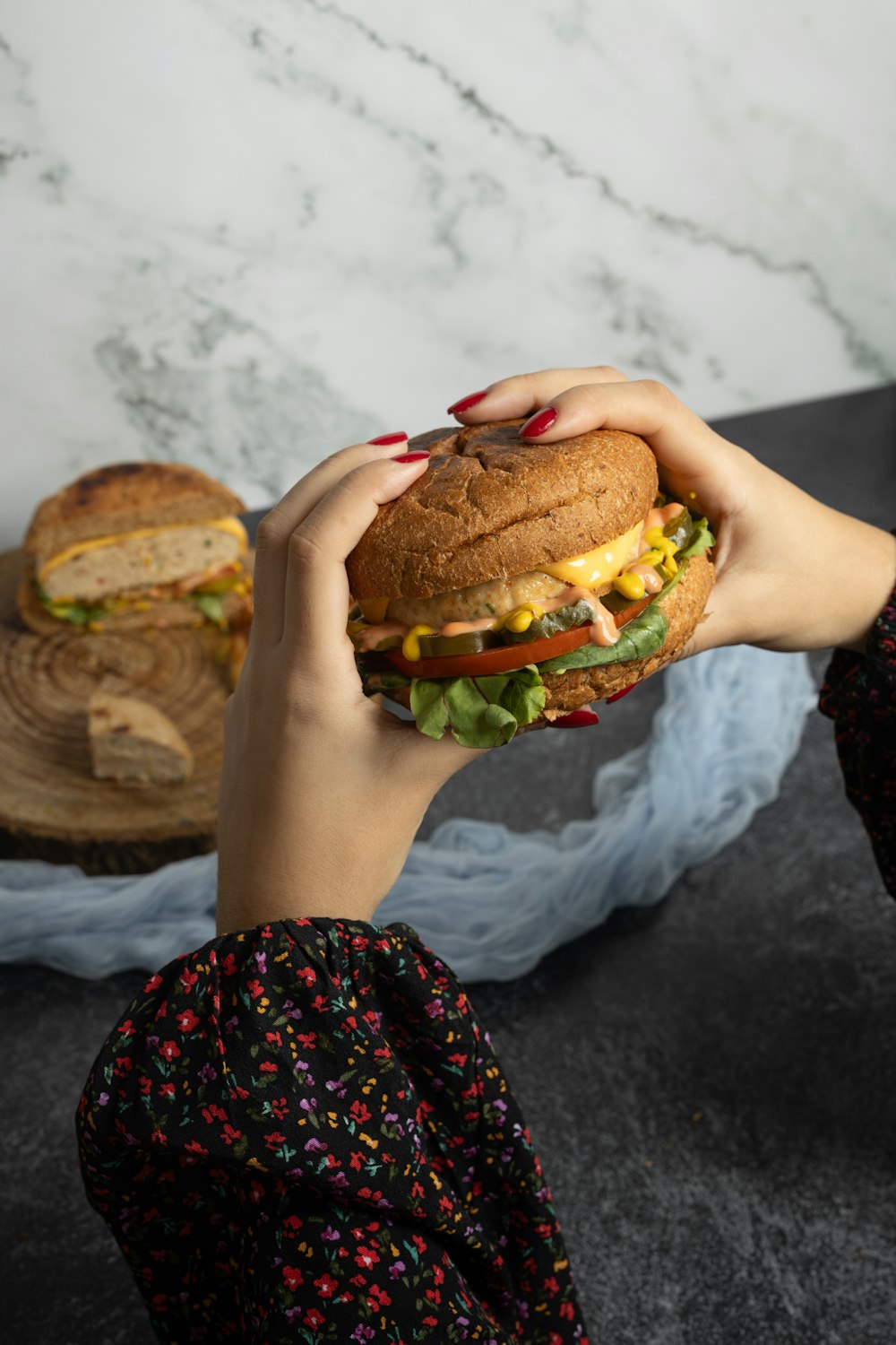 a woman holding a sandwich in front of her face