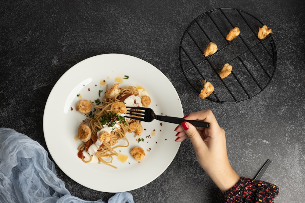 a person is holding a fork over a plate of food