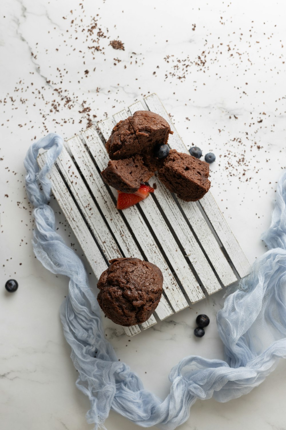 Muffin al cioccolato con fragole e mirtilli su un tagliere di legno