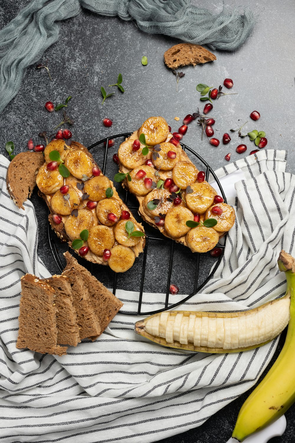 a plate of food with bananas, bread, and pomegranates