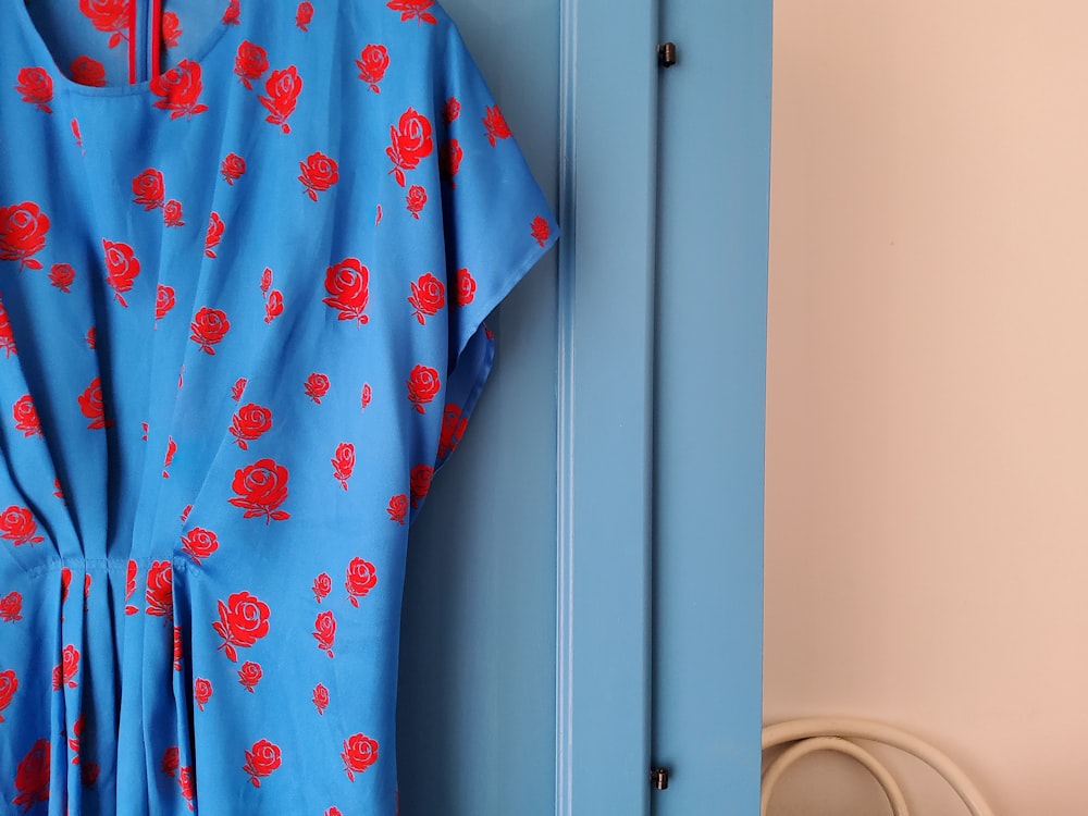 a blue and red dress hanging on a blue door