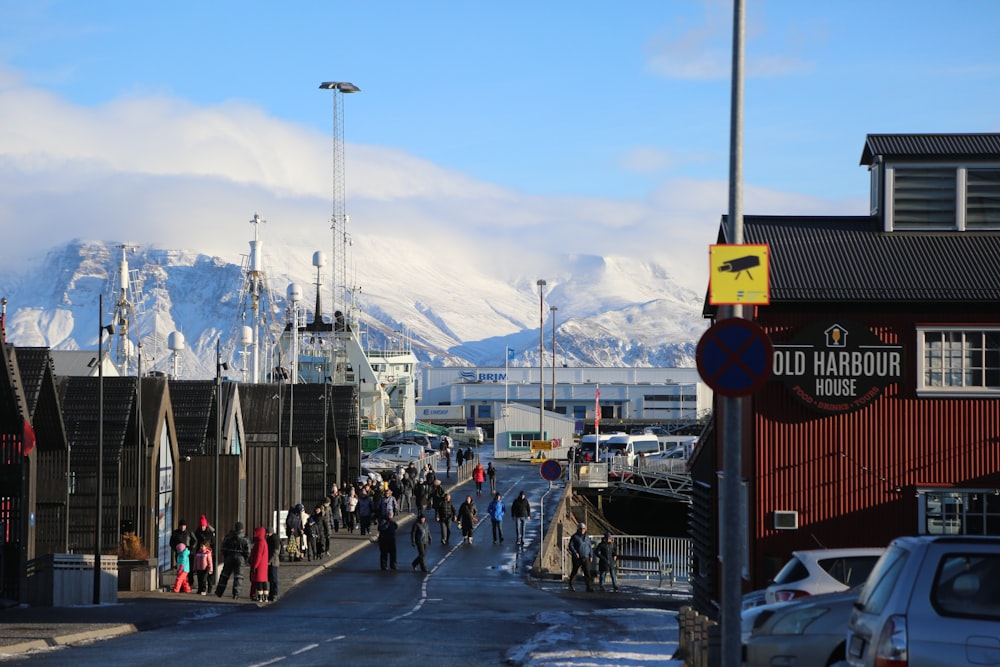 a group of people walking down a street next to a mountain