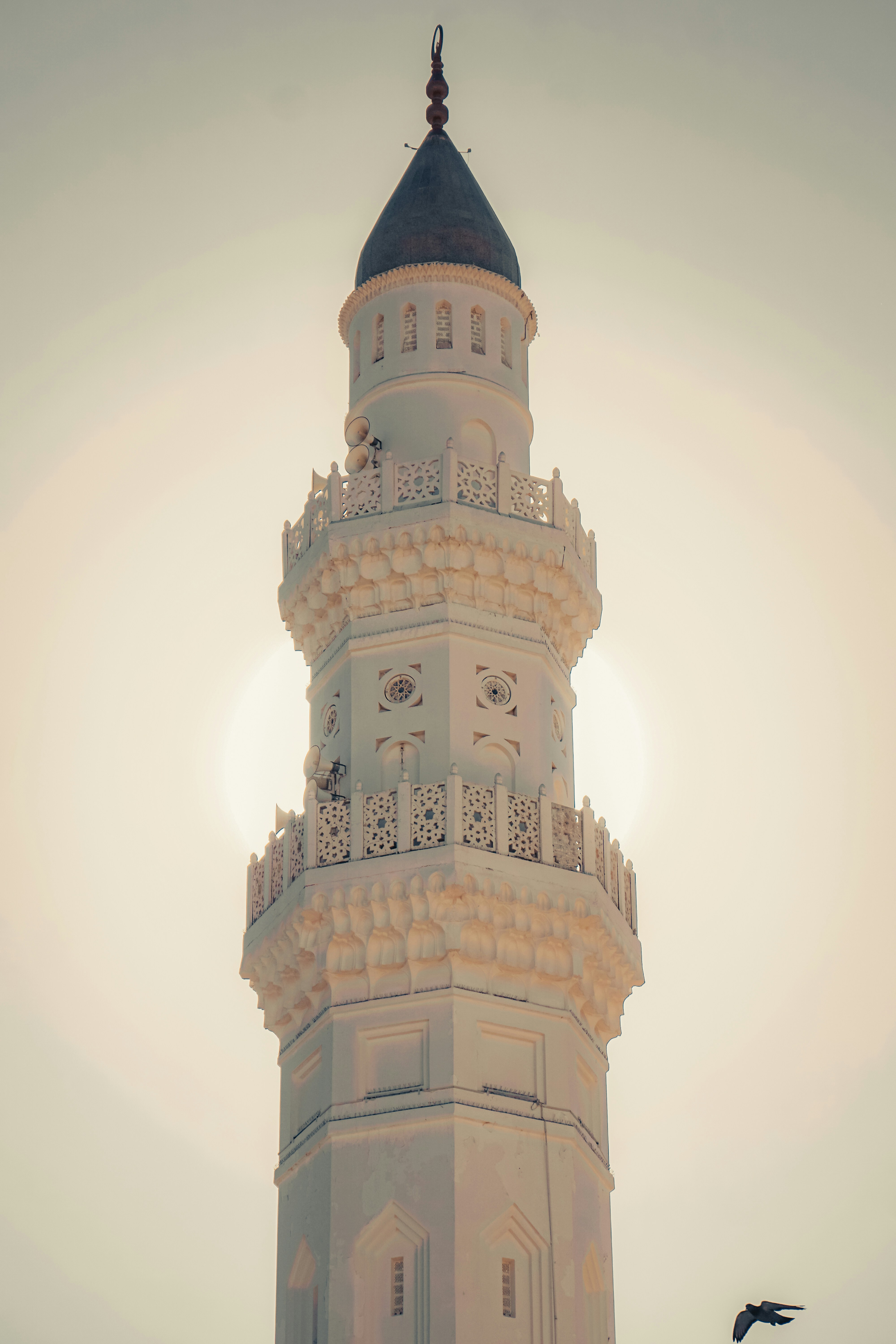 a tall white tower with a clock on it's side