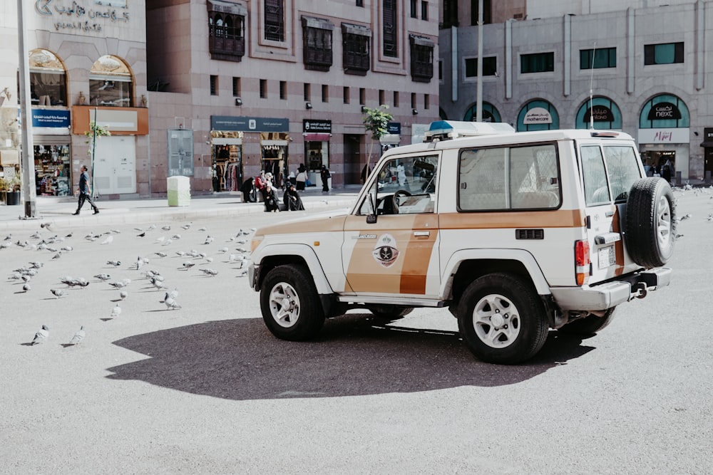 a white and orange jeep parked in front of a building