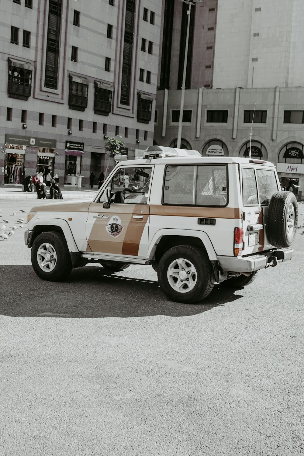a white and brown jeep parked in a parking lot