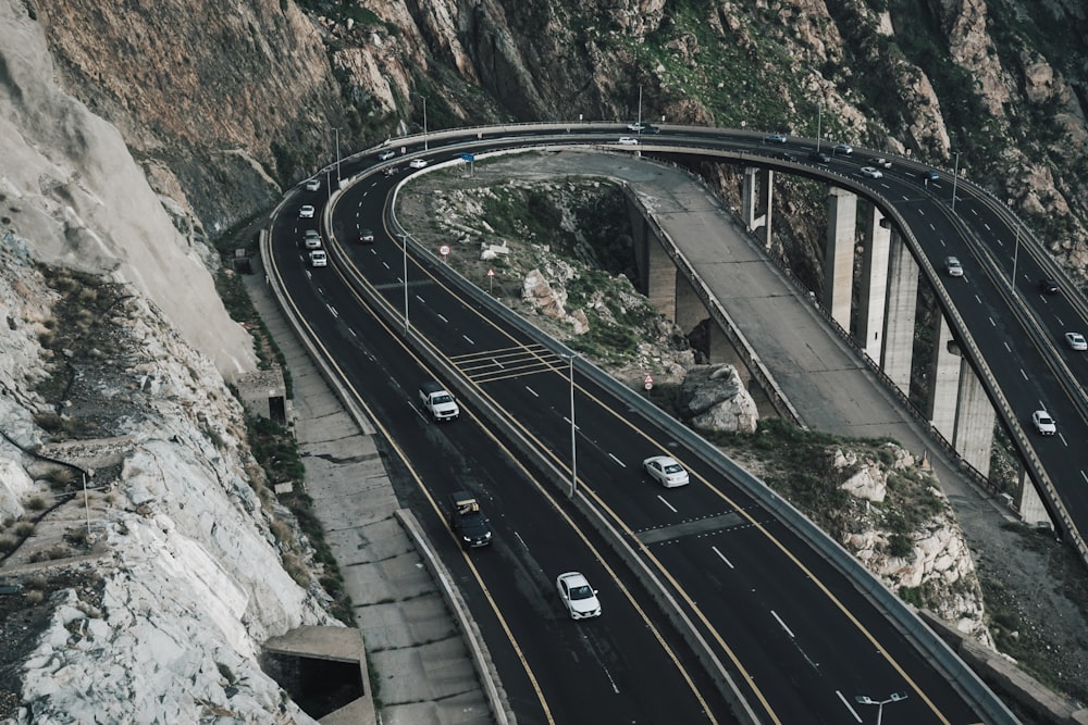 an aerial view of a highway with a mountain in the background