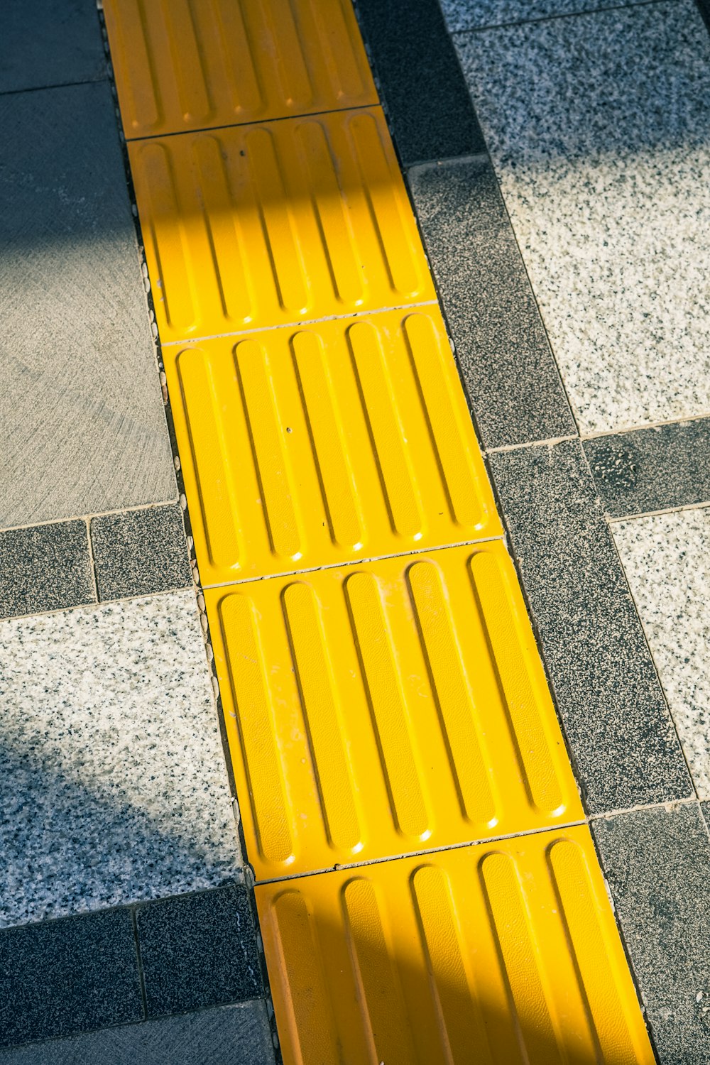 a yellow bench sitting on top of a sidewalk