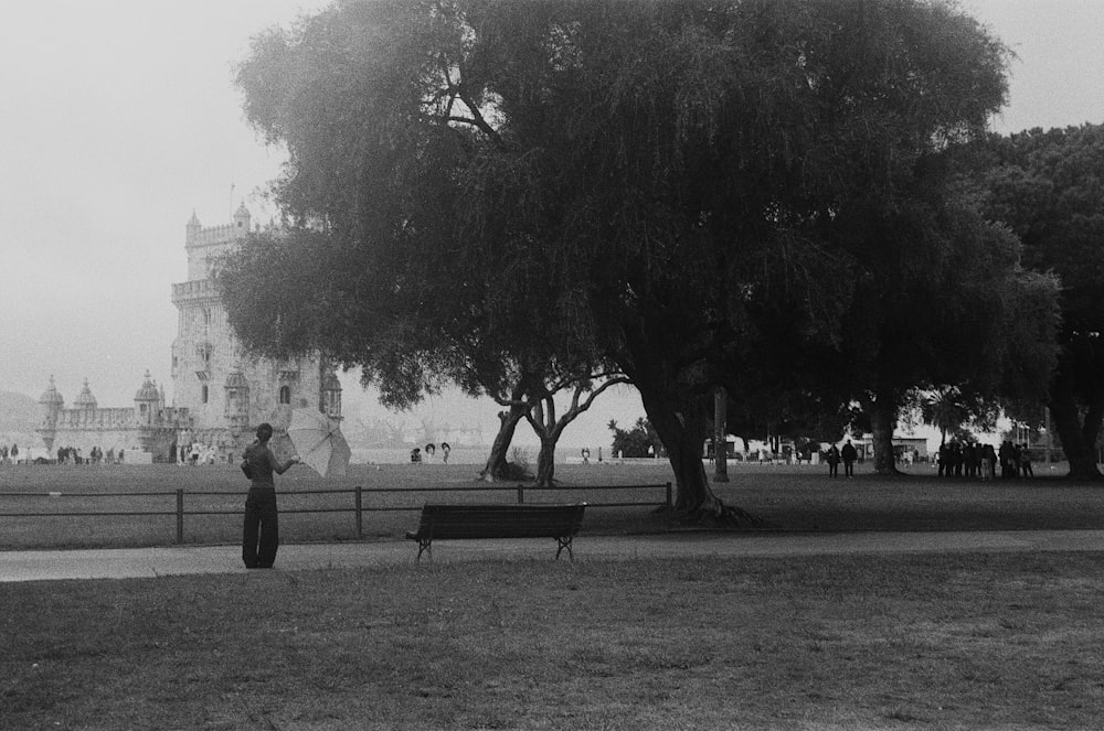 ein Schwarz-Weiß-Foto einer Frau, die unter einem Baum steht