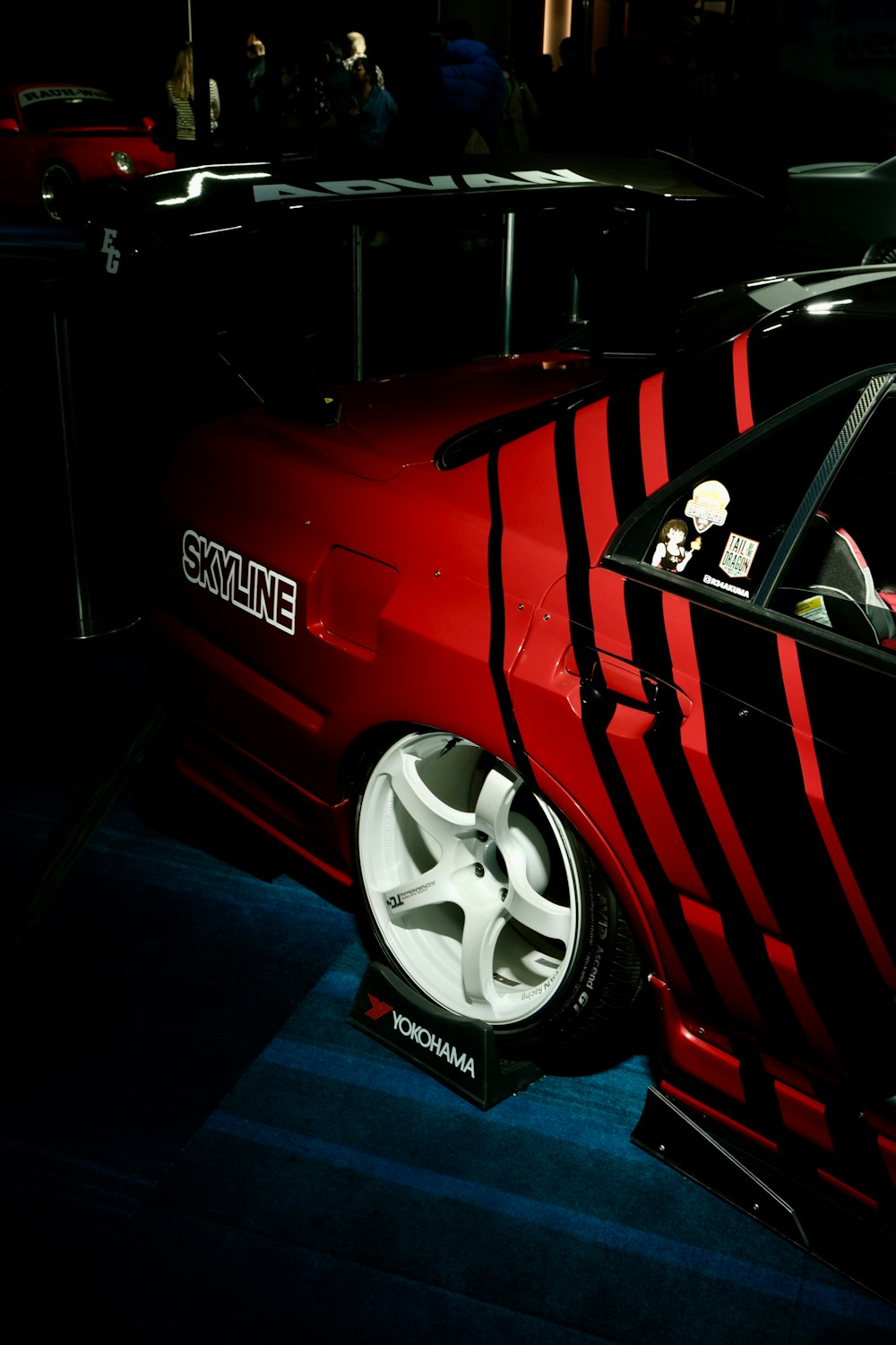 a red car with a black and white stripe on it