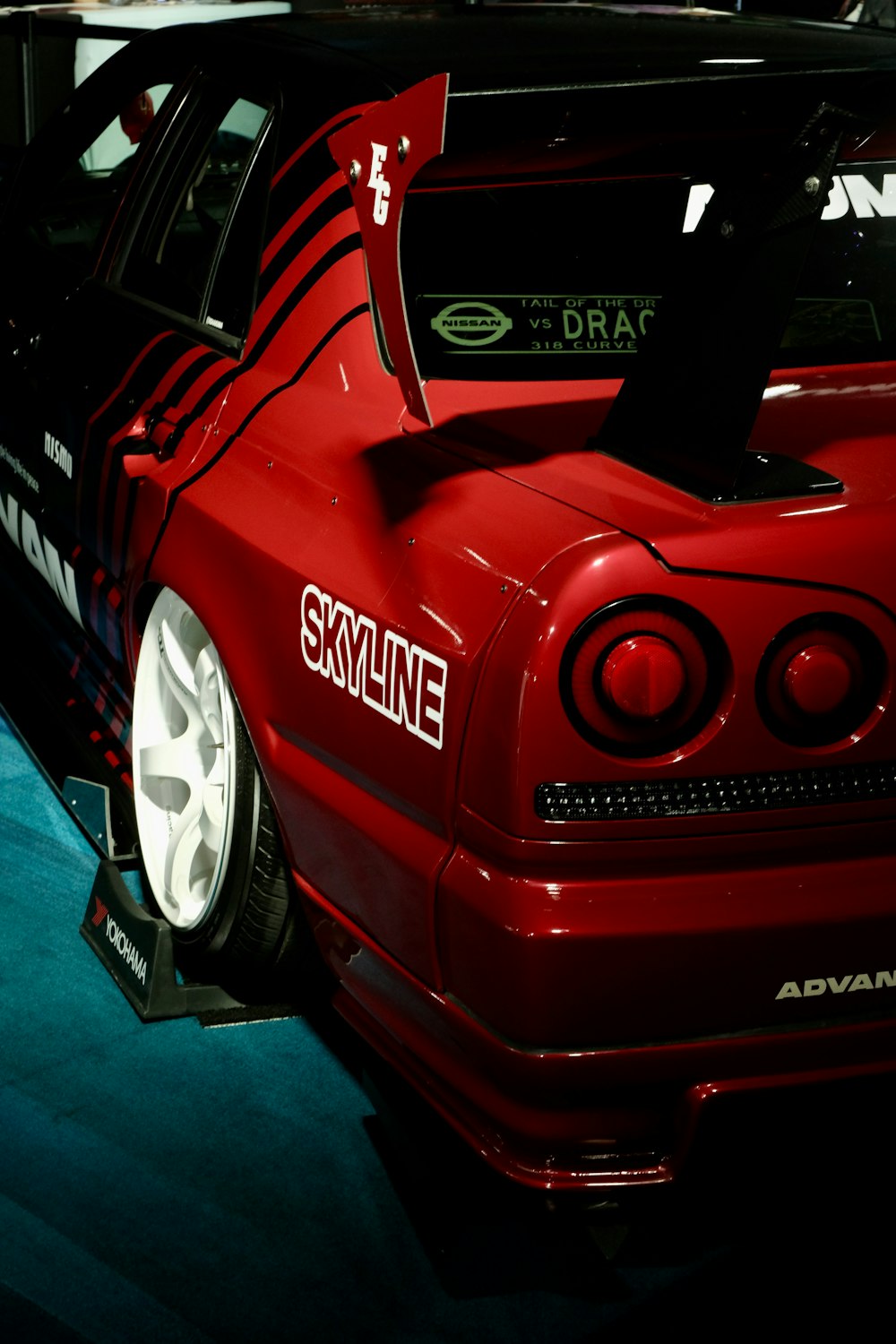 a red car parked in a garage next to another car